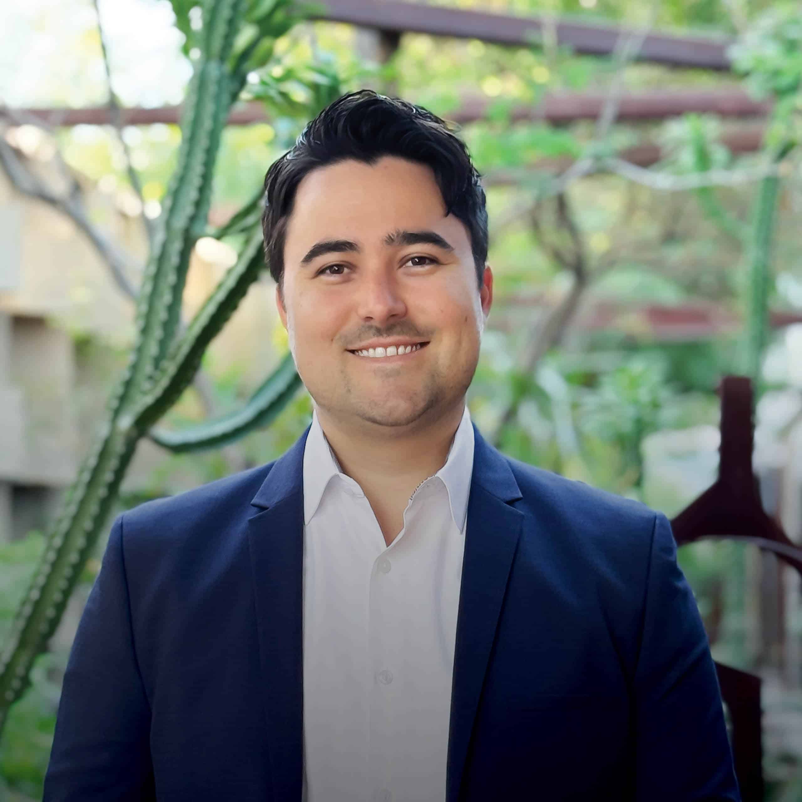 Headshot of Miles Foster, Project Designer for Jones Studio standing in garden area of JSI office.
