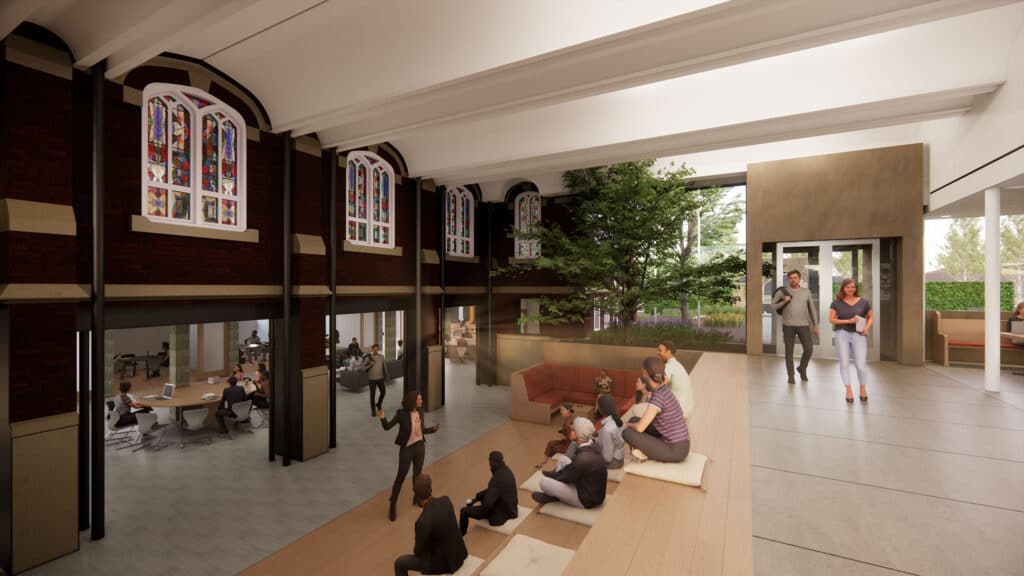 connection of previously exterior brick wall including stained glass windows on upper level, lower level with round tables and office space