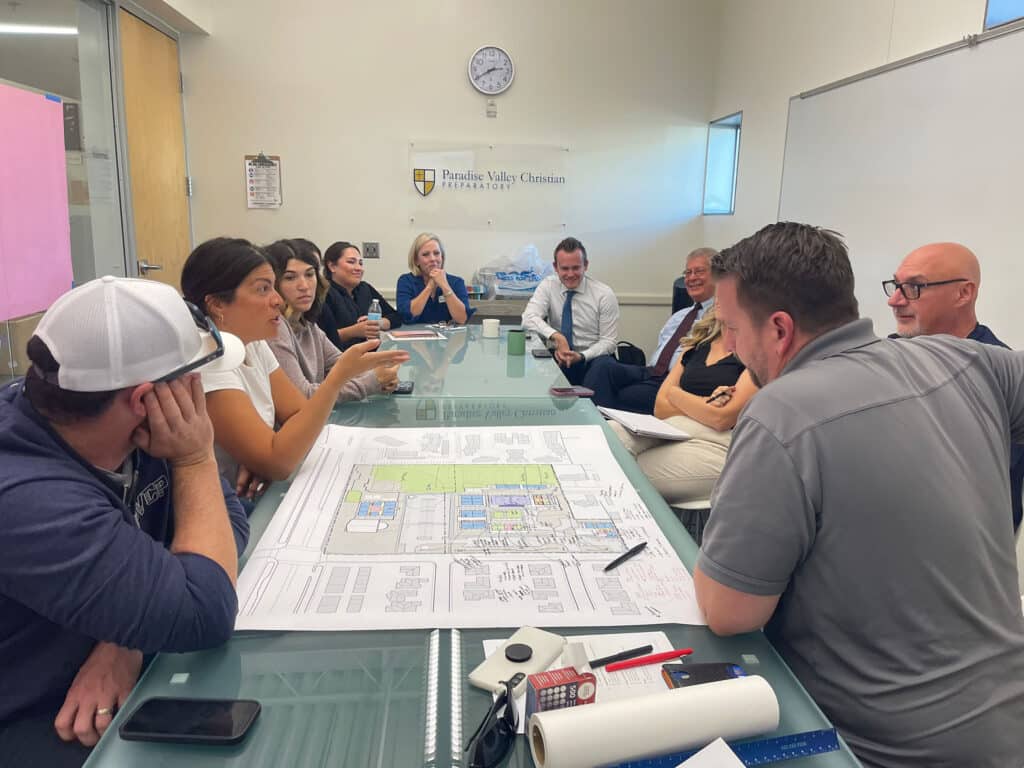 people sitting around table in front of plans for Jones Studio Master Plan for PVCP
